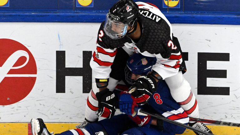 Kashawn Aitcheson, top, of Canada pins Teddy Stiga of Team USA to the ice during the 2024 IIHF ice hockey U18 world championship final match between the United States and Canada in Espoo, Finland, Sunday, May 5, 2024. (Jussi Nukari/Lehtikuva via AP) 