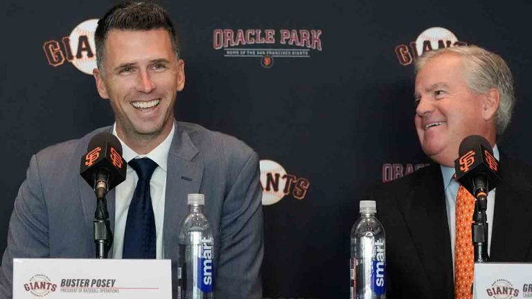 San Francisco Giants president of baseball operations Buster Posey, left, smiles next to chairman Greg Johnson during a news conference in San Francisco, Tuesday, Oct. 1, 2024. (Jeff Chiu/AP)