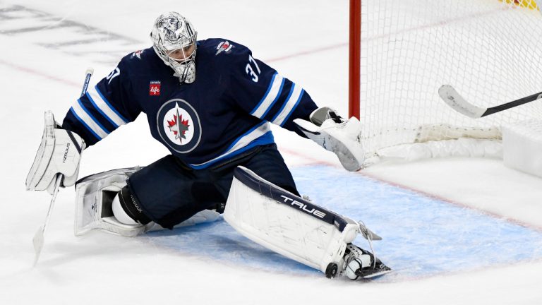 Winnipeg Jets goalie Connor Hellebuyck (37) makes a save on a Minnesota Wild shot during third period NHL hockey action in Winnipeg, Sunday, Oct. 13, 2024. (Fred Greenslade/CP) 