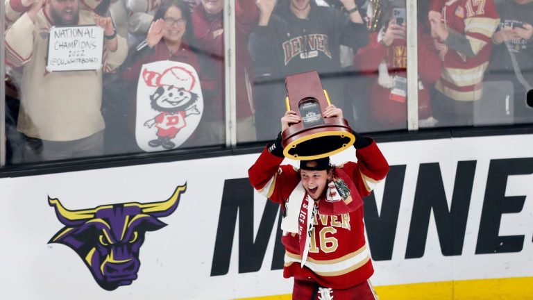 Denver's Cameron Wright holds up the trophy after Denver defeated Minnesota State in the NCAA men's Frozen Four championship college hockey game Saturday, April 9, 2022, in Boston. (Michael Dwyer/AP Photo)