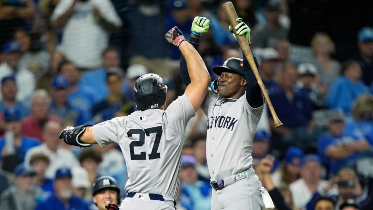 New York Yankees' Giancarlo Stanton (27) is congratulated by teammate Jazz Chisholm Jr. after hitting a solo home run during the eighth inning in Game 3 of an American League Division baseball playoff series against the Kansas City Royals Wednesday, Oct. 9, 2024, in Kansas City, Mo. (Charlie Riedel/AP Photo)