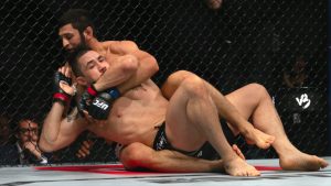 Khamzat Chimaev, back, chokes Robert Whittaker during a middleweight bout at UFC 308 in Abu Dhabi. (Altaf Qadri/AP)