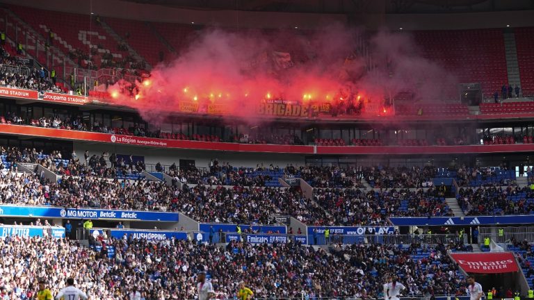 Nantes' fans burn flares during the French League One soccer match between Lyon and FC Nantes at the Groupama stadium in Decines, outside Lyon, France, Sunday, Oct. 6, 2024. (AP/Laurent Cipriani)