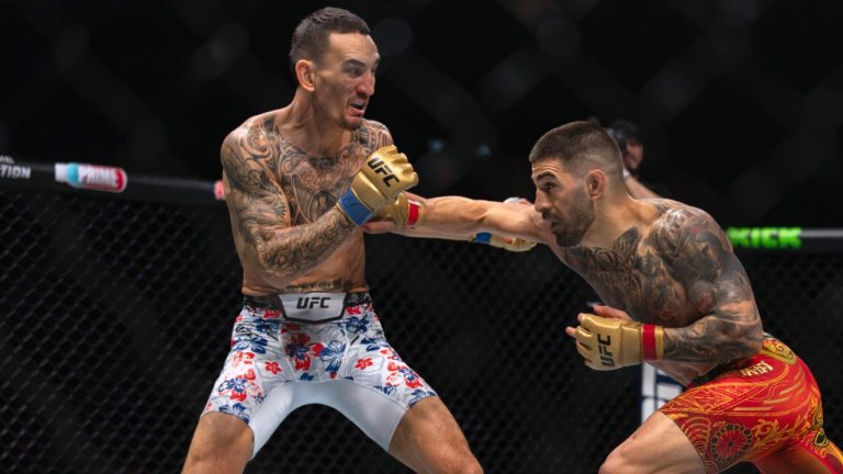 Champion Ilia Topuria, right, punches Max Holloway, left, during a featherweight title bout at UFC 308 in Abu Dhabi, United Arab Emirates. (Altaf Qadri/AP)