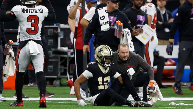 New Orleans Saints wide receiver Chris Olave, bottom, is checked on after losing a fumble that Tampa Bay Buccaneers safety Antoine Winfield Jr. returned for a touchdown during the first half of an NFL football game in New Orleans, Sunday, Oct. 13, 2024. (Butch Dill/AP)