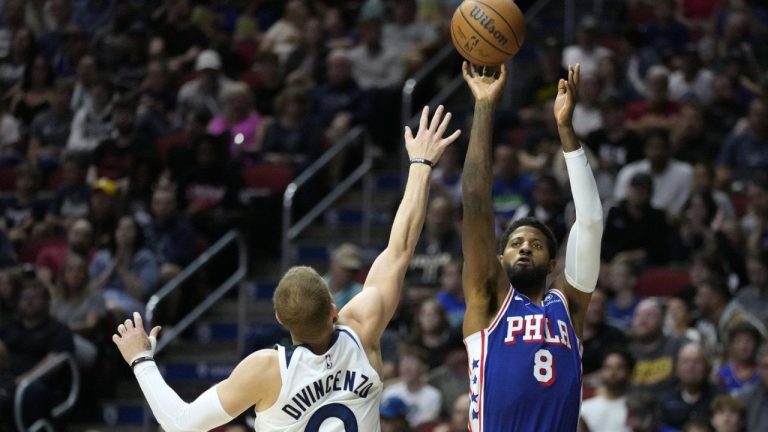 Philadelphia 76ers forward Paul George (8) shoots over Minnesota Timberwolves guard Donte DiVincenzo (0) during the first half of an NBA preseason basketball game, Friday, Oct. 11, 2024, in Des Moines, Iowa. (Charlie Neibergall/AP Photo)
