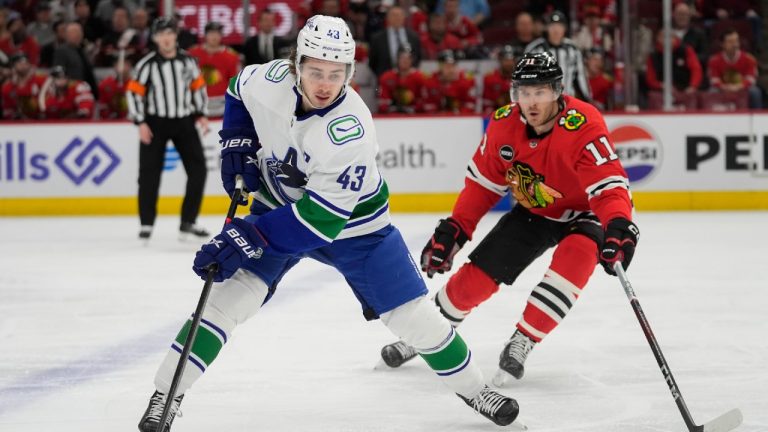 Chicago Blackhawks right wing Taylor Raddysh, right, chases after Vancouver Canucks defenseman Quinn Hughes and the puck during the first period of a hockey game, Tuesday, Feb. 13, 2024, in Chicago. (Erin Hooley/AP)