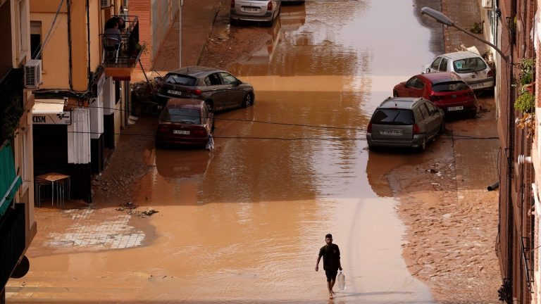 A man carrying water walks through flooded streets in Valencia, Spain, Wednesday, Oct. 30, 2024. (AP)