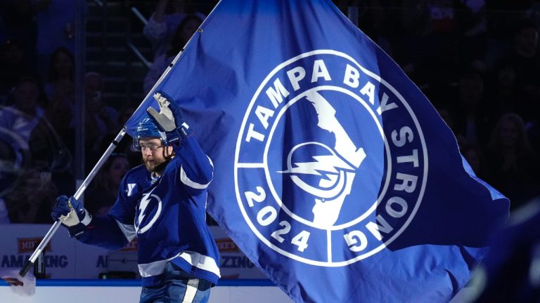 Tampa Bay Lightning defenceman Victor Hedman carries a "Tampa Strong" flag in honor of the victims of Hurricane Milton before an NHL hockey game against the Vancouver Canucks Tuesday, Oct. 15, 2024, in Tampa, Fla. (Chris O'Meara/AP)