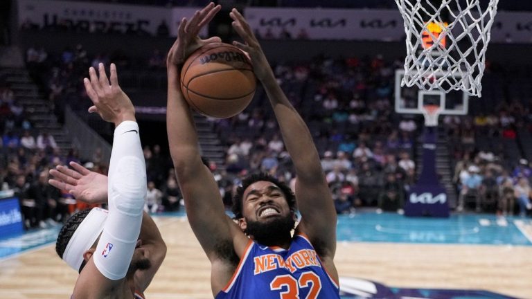 New York Knicks center Karl-Anthony Towns pulls down a rebound as guard Josh Hart looks on during the first half of a preseason NBA basketball game against the Charlotte Hornets, Sunday, Oct. 6, 2024, in Charlotte, N.C. (Chris Carlson/AP)