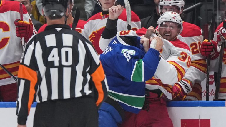 Calgary Flames' Anthony Mantha, back right, and J.T. Miller fight during the first period of an NHL hockey game in Vancouver, on Wednesday, October 9, 2024. (Darryl Dyck/CP)