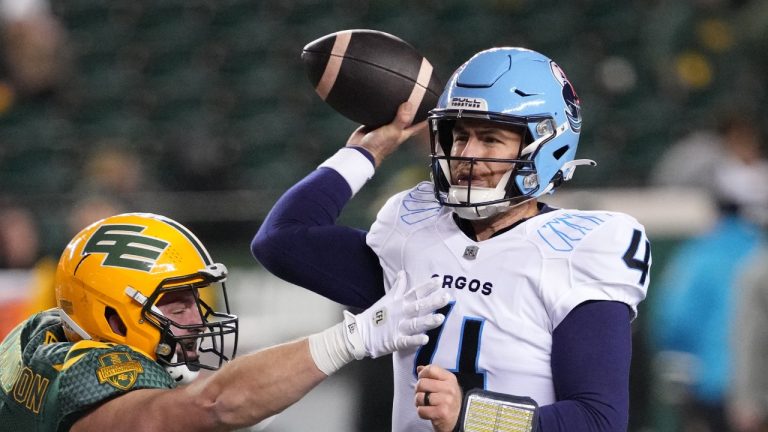 Toronto Argonauts' quarterback Nick Arbuckle (right) is tackled by Edmonton Elks' Jacob Plamondon during second half CFL football action in Edmonton, on Friday, October 25, 2024. (Larry Wong/CP)