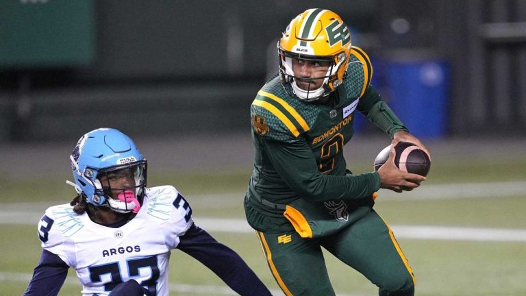 Edmonton Elks quarterback Tre Ford evades a tackle from Toronto Argonauts' Kenneth George Jr. during first half CFL action. (Larry Wong/THE CANADIAN PRESS)
