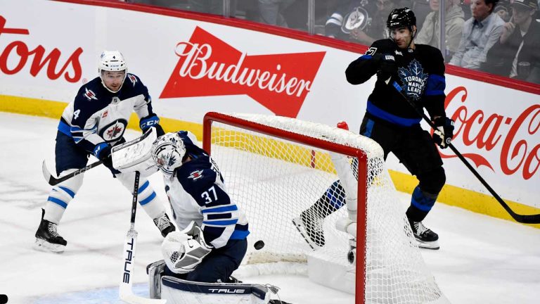 A shot from the Toronto Maple Leafs' William Nylander not pictured, scores on Winnipeg Jets' goaltender Connor Hellebuyck (37) during first period NHL hockey action in Winnipeg on Monday, October 28, 2024. (Fred Greenslade/THE CANADIAN PRESS)