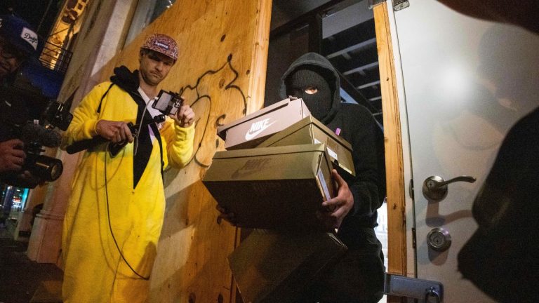 A person carries out items from a ransacked Nike store after the Los Angeles Dodgers defeated the New York Yankees to win the baseball World Series Wednesday, Oct. 30, 2024, in Los Angeles. (Ethan Swope/AP Photo)