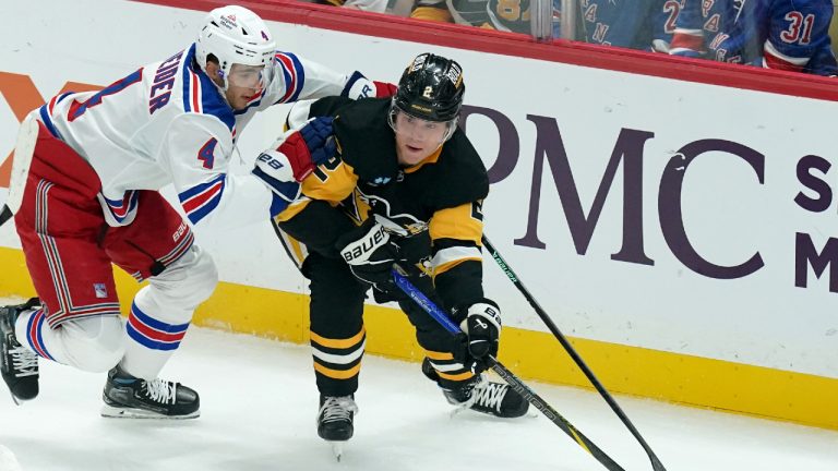 Pittsburgh Penguins' Rutger McGroarty (2) reaches for the puck in front of New York Rangers' Braden Schneider (4) during the first period of an NHL hockey game, Wednesday, Oct. 9, 2024, in Pittsburgh. (Matt Freed/AP)