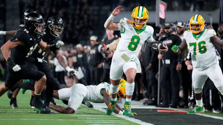 Oregon quarterback Dillon Gabriel (8) tries to stay inbounds while running up the sideline during the second half of an NCAA college football game. (AJ Mast/AP)