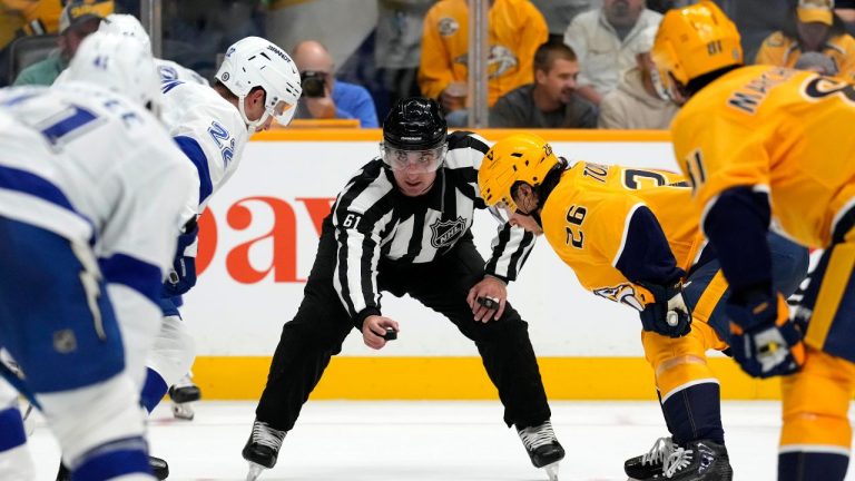 Linesman James Tobias (61) prepares to drop the puck during the second period of a preseason NHL hockey game between the Nashville Predators and the Tampa Bay Lightning Saturday, Sept. 28, 2024, in Nashville, Tenn. (Mark Humphrey/AP Photo)