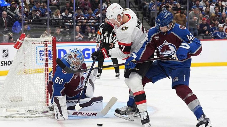 Ottawa Senators left wing Brady Tkachuk, centre, struggles to shoot against Colorado Avalanche goaltender Justus Annunen, left, as Avalanche defenceman Josh Manson, right, battles for position in the second period of an NHL hockey game. (David Zalubowski/AP)