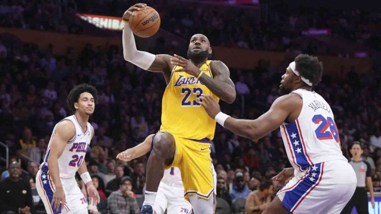 Los Angeles Lakers forward LeBron James, center, shoots as Philadelphia 76ers guard Jared McCain, left, and forward Guerschon Yabusele defend during the first half of an NBA basketball game, Friday, Nov. 8, 2024, in Los Angeles. (Mark J. Terrill/AP)