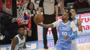 Cleveland Cavaliers' Darius Garland (10) lays in a shot as Charlotte Hornets' Josh Green, right, defends and Hornets' Brandon Miller (24) watches during the first half of an NBA basketball game in Cleveland, Sunday, Nov 17, 2024. (Phil Long/AP)