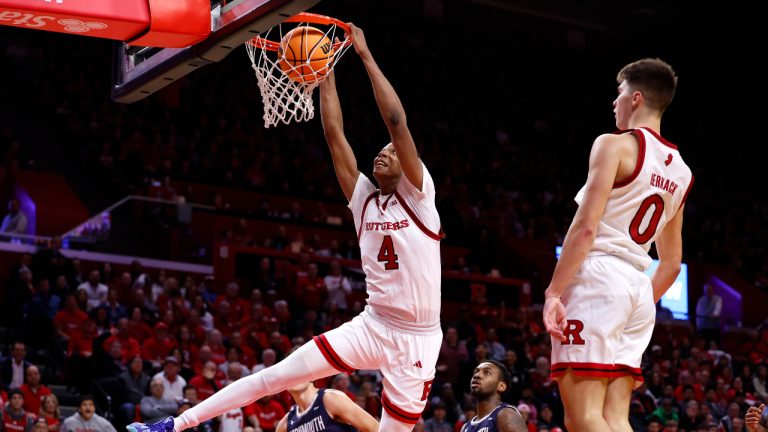 Rutgers guard Jordan Derkack (0) watches Ace Bailey (4) dunk against Monmouth guard Jack Collins (13) and forward Chris Morgan (21) during the second half of an NCAA college basketball game, Friday, Nov. 15, 2024, in Piscataway, N.J. (AP Photo/Noah K. Murray)