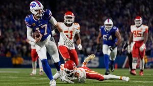 Buffalo Bills quarterback Josh Allen (17) slips past Kansas City Chiefs cornerback Nazeeh Johnson (13) to score on a 26-yard run during the second half of an NFL football game Sunday, Nov. 17, 2024, in Orchard Park, N.Y. (Julia Demaree Nikhinson/AP)