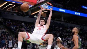 Houston Rockets center Alperen Sengun (28) hangs on the rim after a dunk during the second half of an Emirates NBA cup basketball game against the Minnesota Timberwolves. (Abbie Parr/AP)