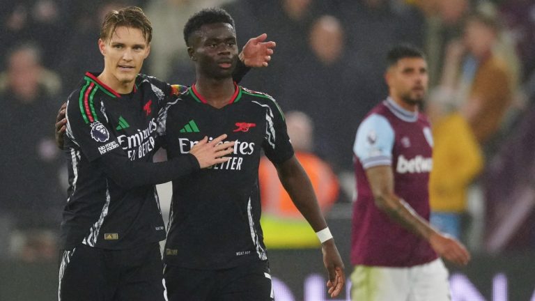 Arsenal's Martin Odegaard, left, celebrates with Arsenal's Bukayo Saka after scoring his side's third goal during the English Premier League soccer match between West Ham and Arsenal at the London Stadium in London, Saturday, Nov. 30, 2024. (AP Photo/Dave Shopland)