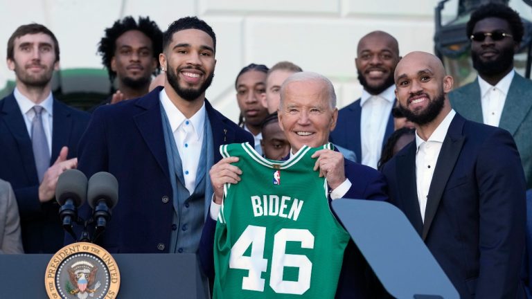 President Joe Biden, center, flanked by Boston Celtics players Jayson Tatum, left, and Derrick White, holds up a jersey they presented to him during an event to celebrate the team's victory in the 2024 National Basketball Association Championship, on the South Lawn of the White House in Washington, Thursday, Nov. 21, 2024. (AP Photo/Susan Walsh)