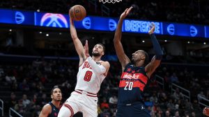 Chicago Bulls guard Zach LaVine (8) drives to the basket and shoots the ball against Washington Wizards forward Alexandre Sarr (20) during the first half of an NBA basketball game, Tuesday, Nov. 26, 2024, in Washington. (AP Photo/Terrance Williams)