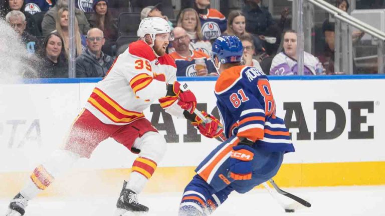 Calgary Flames Anthony Mantha (39) skates with the puck ahead of Edmonton Oilers Noel Hoefenmayer (81) during first period NHL preseason action in Edmonton on Monday September 23, 2024. (Amber Bracken/CP)