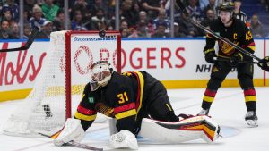 The puck bounces over the head of Vancouver Canucks goalie Arturs Silovs and stays out of the net as Quinn Hughes watches during the second period 
 against the New Jersey Devils, in Vancouver, Oct. 30, 2024. (CP/Darryl Dyck)