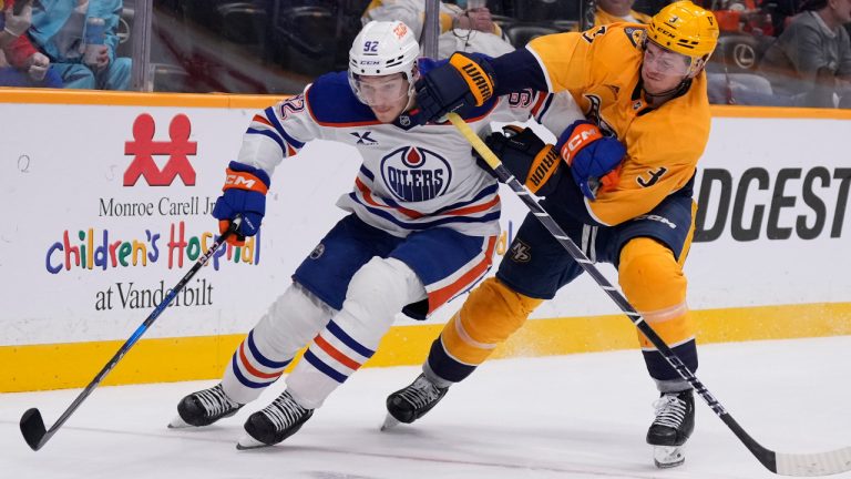 Edmonton Oilers right wing Vasily Podkolzin (92) skates the puck past Nashville Predators defenceman Jeremy Lauzon (3) during the third period of an NHL hockey game Thursday, Oct. 31, 2024, in Nashville, Tenn. (George Walker IV/AP) 