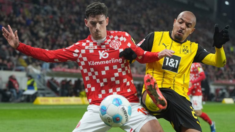 Mainz's Anthony Caci, left, and Dortmund's Donyell Malen, right, challenge for the ball during the German Bundesliga soccer match between 1. FSV Mainz 05 and Borussia Dortmund in Mainz, Germany, Saturday, Nov. 9, 2024. (Thomas Frey/dpa via AP) 