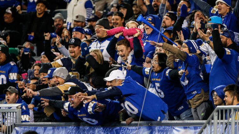 Winnipeg Blue Bombers fans celebrate a touchdown against the Saskatchewan Roughriders during the first half of CFL Western Conference Final action in Winnipeg Saturday, November 9, 2024. (CP/John Woods)