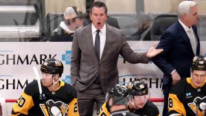 Pittsburgh Penguins head coach Mike Sullivan, centre top, makes his point to linesman Matt MacPherson, center bottom, during the first period of an NHL hockey game against the Dallas Stars in Pittsburgh, Monday, Nov. 11, 2024. (Gene J. Puskar/AP)