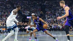 Sacramento Kings guard De'Aaron Fox (5) drives to the basket with Minnesota Timberwolves forward Jaden McDaniels (3) defending during the first half of an Emirates NBA Cup basketball game Friday, Nov. 15, 2024, in Sacramento, Calif. (Sara Nevis/AP)