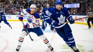 Edmonton Oilers centre Connor McDavid and Toronto Maple Leafs defenceman Jake McCabe chase the puck during third period action, in Toronto, Saturday, Nov. 16, 2024. (CP/Christopher Katsarov)