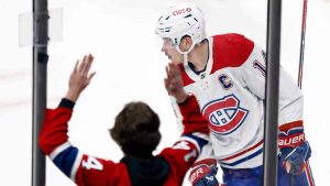 Montreal Canadiens forward Nick Suzuki, right, skates in front of a fan after scoring the game-winning overtime goal against the Columbus Blue Jackets during an NHL hockey game in Columbus, Ohio, Wednesday, Nov. 27, 2024. (Paul Vernon/AP)