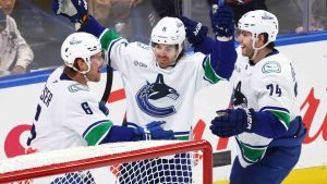 Vancouver Canucks right wing Conor Garland (8) celebrates after his goal with right wing Brock Boeser (6) and left wing Jake DeBrusk (74) during the third period of an NHL hockey game against the Buffalo Sabres, Friday, Nov. 29, 2024, in Buffalo, N.Y. (Jeffrey T. Barnes/AP)