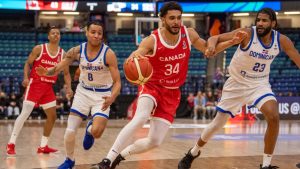 Team Canada's Jackson Rowe moves the ball past Team Dominican Republic's LJ Figueroa during first half FIBA men's AmeriCup 2025 Qualifiers action in Saskatoon, Sask. on Thursday, November 21, 2024. THE CANADIAN PRESS/Liam Richards