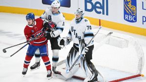 Utah Hockey Club's Maveric Lamoureux (10) defends against Montreal Canadiens' Cole Caufield (13) as the net of Utah's goaltender Karel Vejmelka (70) comes off its pegs during second period NHL hockey action in Montreal, Tuesday, November 26, 2024. (Graham Hughes/CP)