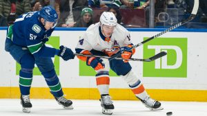 Vancouver Canucks' Tyler Myers (left) tries to check New York Islanders' Bo Horvat off the puck during first period NHL hockey action in Vancouver, B.C., Thursday, November 14, 2024. (Rich Lam/CP)