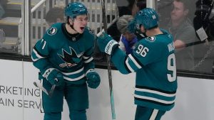 San Jose Sharks centre Macklin Celebrini, left, is congratulated by defenseman Jake Walman (96) after scoring the winning goal during overtime of an NHL hockey game against the Detroit Red Wings in San Jose, Calif., Monday, Nov. 18, 2024. (Jeff Chiu/AP)