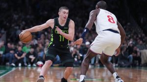 Boston Celtics guard Payton Pritchard (11) drives to the basket against Los Angeles Clippers guard Kris Dunn (8) during the second half of an NBA basketball game, Monday, Nov. 25, 2024, in Boston. (AP Photo/Charles Krupa)