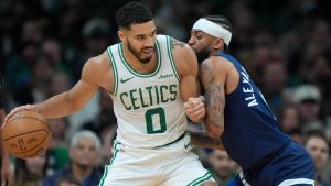 Boston Celtics forward Jayson Tatum (0) looks for an opening around Minnesota Timberwolves guard Nickeil Alexander-Walker, right, in the first half of an NBA basketball game, Sunday, Nov. 24, 2024, in Boston. (AP Photo/Steven Senne)