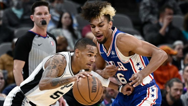 San Antonio Spurs' Dejounte Murray (5) drives against Philadelphia 76ers' Charlie Brown Jr. during the first half of an NBA basketball game, Sunday, Jan. 23, 2022, in San Antonio. (AP Photo/Darren Abate)