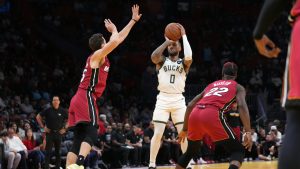 Milwaukee Bucks guard Damian Lillard (0) shoots over Miami Heat forward Duncan Robinson, left, and forward Jimmy Butler (22) during the first half of an Emirates NBA Cup basketball game. (Lynne Sladky/AP)