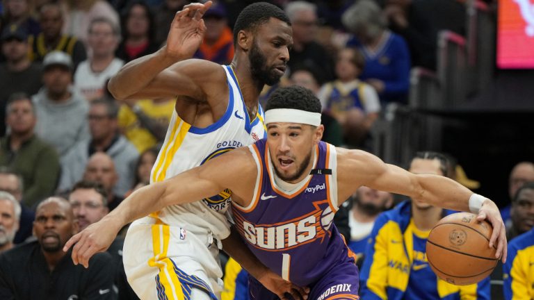 Phoenix Suns guard Devin Booker (1) drives around Golden State Warriors forward Andrew Wiggins during the first half of an NBA basketball game. (Rick Scuteri/AP)